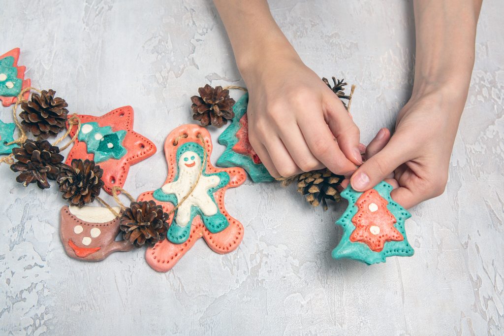 تحتوي هذه الصورة على سمة alt فارغة؛ اسم الملف هو homemade-home-decoration-christmas-children-s-hands-are-holding-homemade-garland-gingerbread-men-are-made-salted-dough-cones-1024x682.jpg