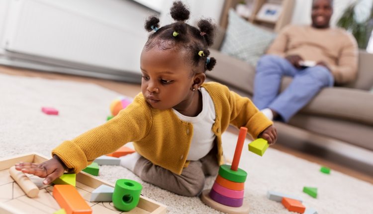 african baby girl playing with toy blocks at home