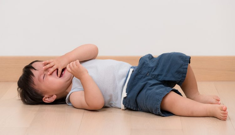 Asian little boy cry and lying on floor