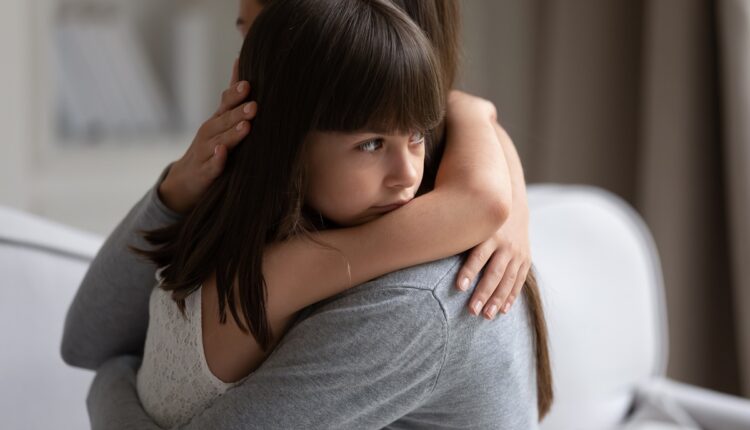Close up view of upset little daughter cuddling mother